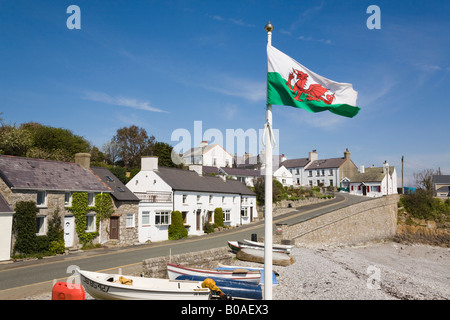 Seafront cottages boats on beach with Welsh flag flying in small historic village on coast. Moelfre Isle of Anglesey North Wales UK Britain Stock Photo