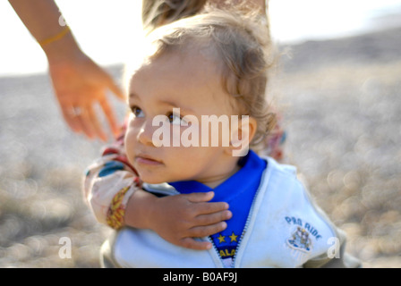 Portrait of a beautiful and tender mixed race small girl half thai hugging a baby Stock Photo