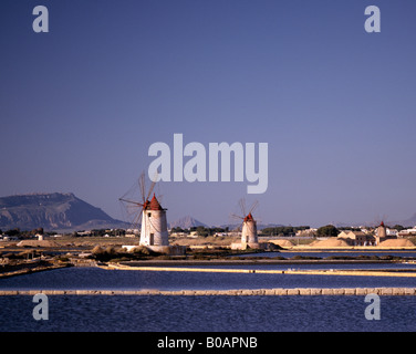 The Windmills and salt flats near Trapani and Marsala with Erice in the background Sicily Italy EU. Stock Photo