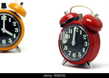 red and orange color alarm clock at twelve oclock isolated on white background Stock Photo