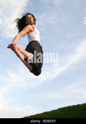 A young woman girl jumping on a trampoline, UK Stock Photo