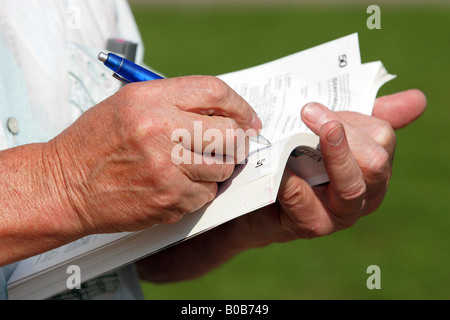 Hands of a man writing in a catalogue with a ballpoint pen Stock Photo