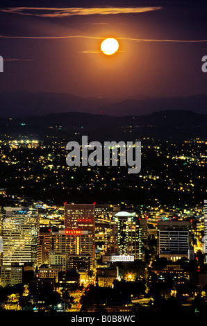 Moon rising over the downtown buildings of Portland Oregon at dusk USA Stock Photo