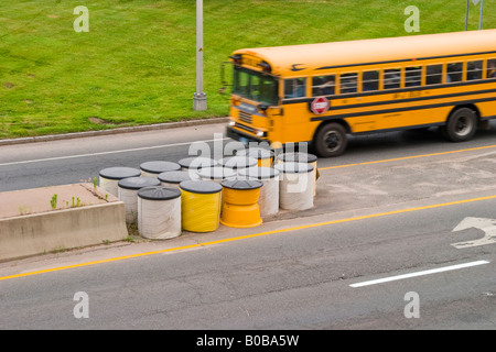 Containers of sand on a city street to help prevent automobiles from hitting a concrete barrier Stock Photo