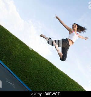 A teenage girl jumping on a trampoline, UK