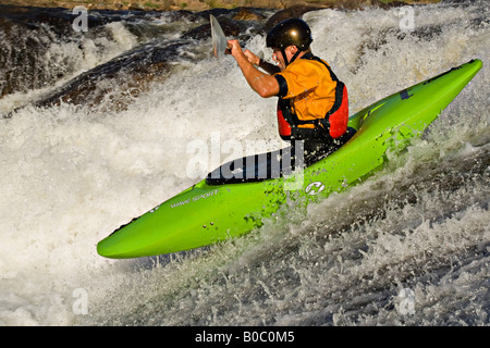 A whitewater kayaker descends a waterfall on the Dead River near Marquette Michigan Stock Photo