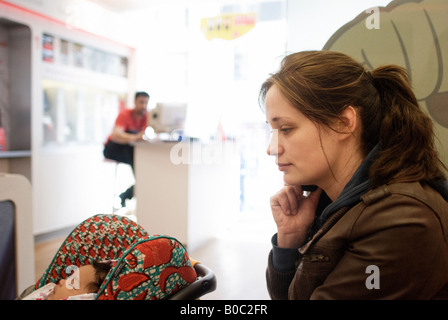 Young mother in a mobile phone store making complain over the phone to custmer services London England Stock Photo