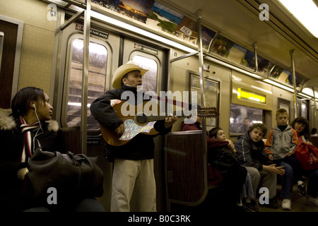 Mexican man plays his guitar and sings on a New York City subway train in Brooklyn Stock Photo