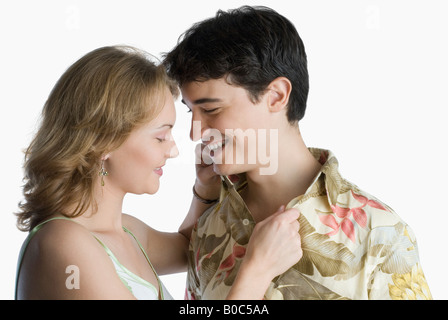 Side profile of a young woman adjusting a young man's collar Stock Photo