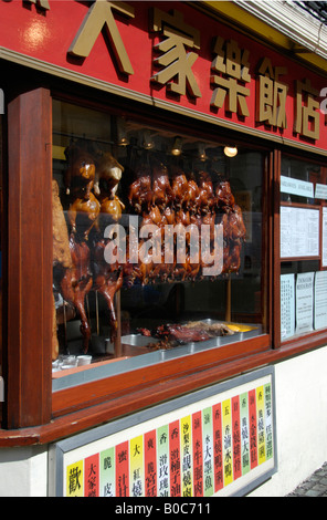 Roasted chickens and ducks hanging in Chinese restaurant window Chinatown London Stock Photo