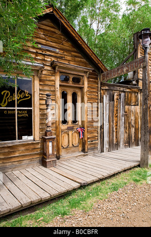 Image of the exterior of the Elkhorn Barber Shop and wooden plank walk way in Nevada City Montana Stock Photo