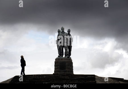 A TOURIST LOOKS AT THE COMMANDO REGIMENT WAR MEMORIAL UNDER DARK SKIES AT SPEAN BRIDGE,NEAR FORT WILLIAM IN SCOTLAND,UK. Stock Photo