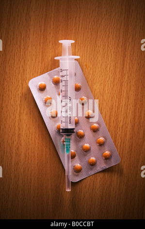 Hypodermic injection and medicine pills Stock Photo