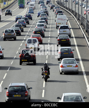 A MOTORCYCLIST  FILTERS THROUGH          TRAFFIC QUEUES ON THE M6 MOTORWAY,NORTHBOUND NEAR JUCTION 11,CANNOCK,STAFFS,UK. Stock Photo