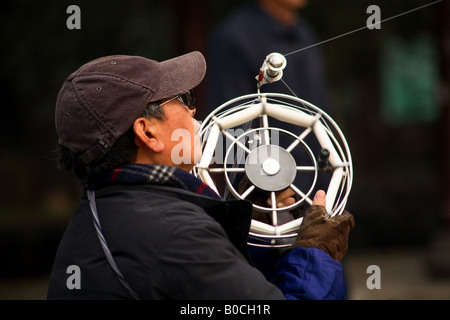 a old Chinese man is watching his kite Stock Photo