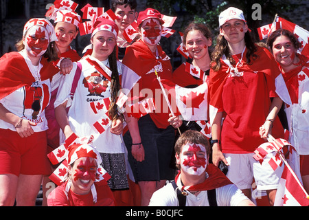 Teenagers with Canadian flags dressed in red and white Canada Day at the Parliament Buildings on Parliament Hill Ottawa Ontario Stock Photo