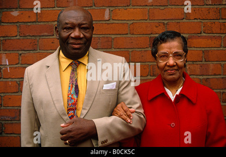 Mr and Mrs Daily a happily married couple stand in their smartest clothes against a brick wall outside their Birmingham home Stock Photo