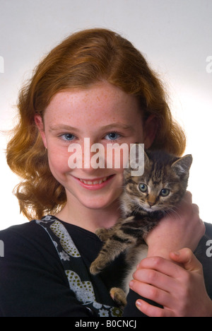 Red haired freckle faced 11 year old girl with kitten Stock Photo