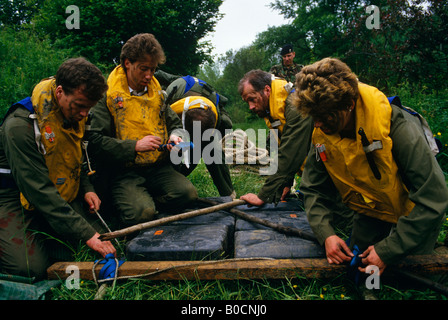 Volunteer member of the Territorial Army use initiative and teamwork to build a makeshift raft during initiative manoeuvres Stock Photo