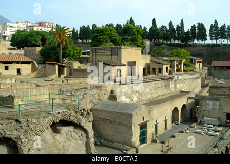 Former wharf buildings sea front of Roman city of Herculaneum near Naples in Italy with modern city of Ercolano above the ruins Stock Photo