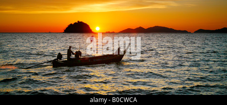 Sunset and local sea gypsy in long-tailed boat, Andaman Sea and Straights of Malacca, Thailand Stock Photo