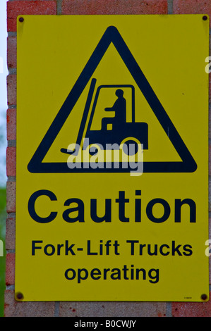 Yellow Caution fork lift trucks operating sign, portrait photograph Stock Photo