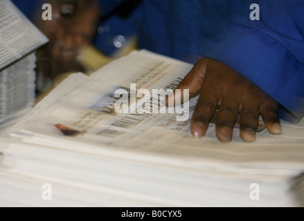 A worker checks copies of Wall Street Journal newspapers as they are printed on printing presses at Newsfax in East London U K Stock Photo