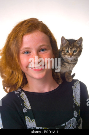 Red haired freckle faced 11 year old girl with kitten Stock Photo