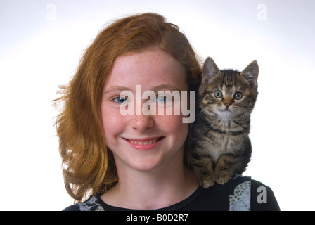 Red haired freckle faced 11 year old girl with kitten Stock Photo