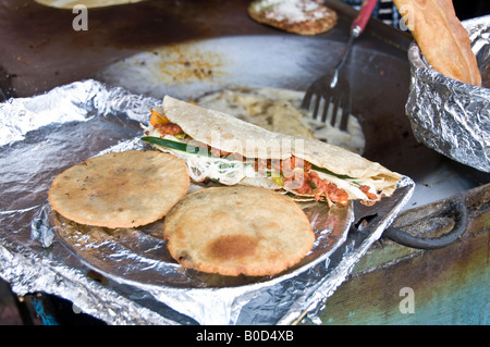 Tacos (top) and Empanadas (two at the bottom) being cooked and sold in a street market in Puebla, Mexico. Tasty, Mexican food. Stock Photo