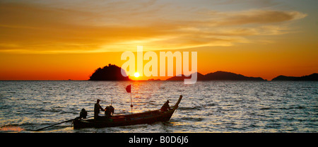 Sunset and local sea gypsy in long-tailed boat, Andaman Sea and Straights of Malacca, Thailand Stock Photo