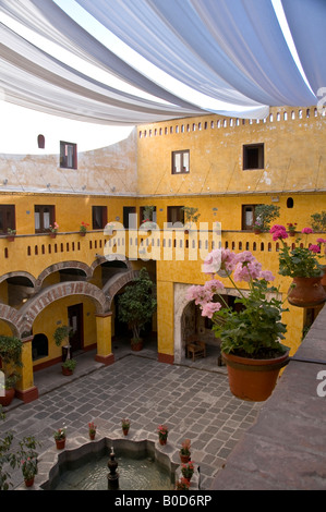 Interior courtyard of the Camino Real hotel in Puebla, Mexico. Surrounded by ancient columns, the roof covered by giant shade. Stock Photo