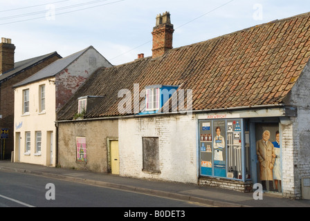 Village store shop closed down and abandoned houses Chatteris Cambridgeshire. Wall painting mural art work  depicting the shop keepers UK HOMER SYKES
