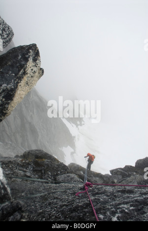 Climber rappelling into the fog on The Throne, Little Switzerland, Pika Glacier, Alaska Stock Photo