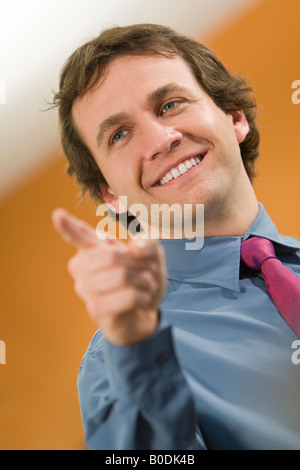 A successful young man chooses points and smiles Stock Photo