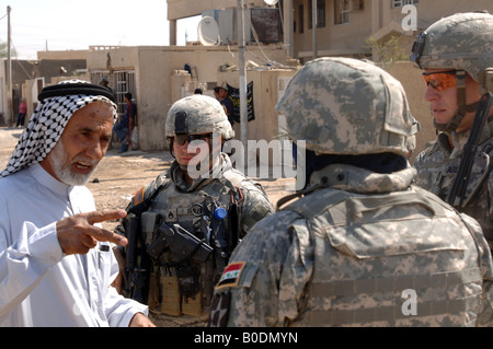 A village official explains village water supply problems to U S Army soldiers as they conduct a routine patrol in Isslah Iraq Stock Photo