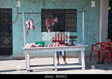 Road-side butcher's shop near Merida, Mexico. The wife and child watch whilst the father hacks up the meat outside. Stock Photo