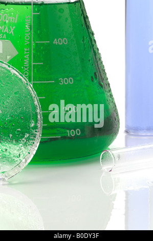 Beakers With Colorful Liquids On Wet Counter White Background Stock Photo