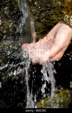 Water cascading off rock woman's wet hand, ornamental water feature, Mijas Pueblo, Costa del Sol, Andalucia, Spain Stock Photo