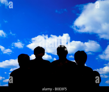 four silhouetted people looking at cloud formation Stock Photo