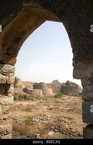 The ruins of Tughluqabad Fortress in Delhi, seen through an arch of a partially destroyed wall. Stock Photo