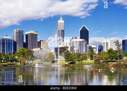 Perth's skyscrapers towering above an inner city park. A rainbow appears in the fountain's spray. Perth, Australia Stock Photo