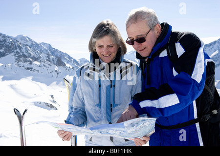 Couple reading piste map Stock Photo