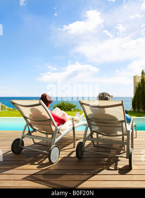 Mature couple relaxing by the pool Stock Photo
