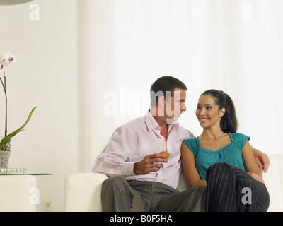 Couple sitting on couch with cake Stock Photo