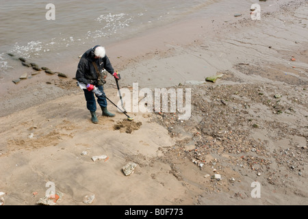 Metal Detectorist searches the Foreshore near Greenwich Pier Stock Photo