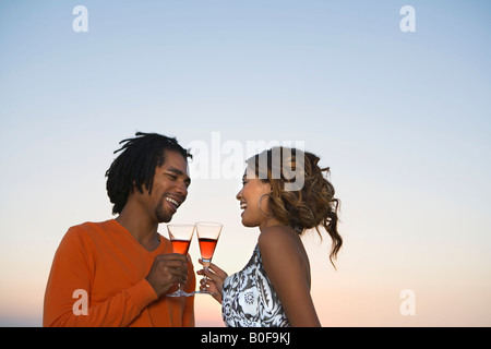 Young couple drinking wine by sunset Stock Photo