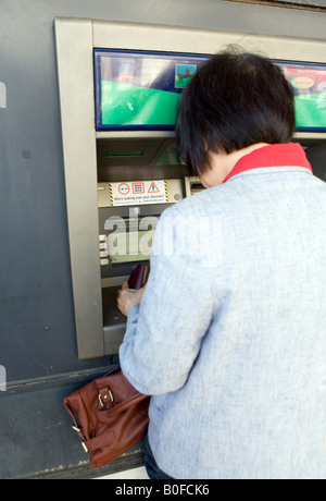 Woman at Bank Cash Dispenser London Stock Photo