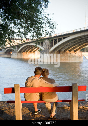 Couple on bench by river Stock Photo