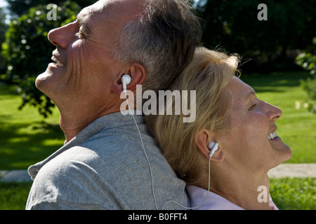 Man and woman listening to earphones Stock Photo